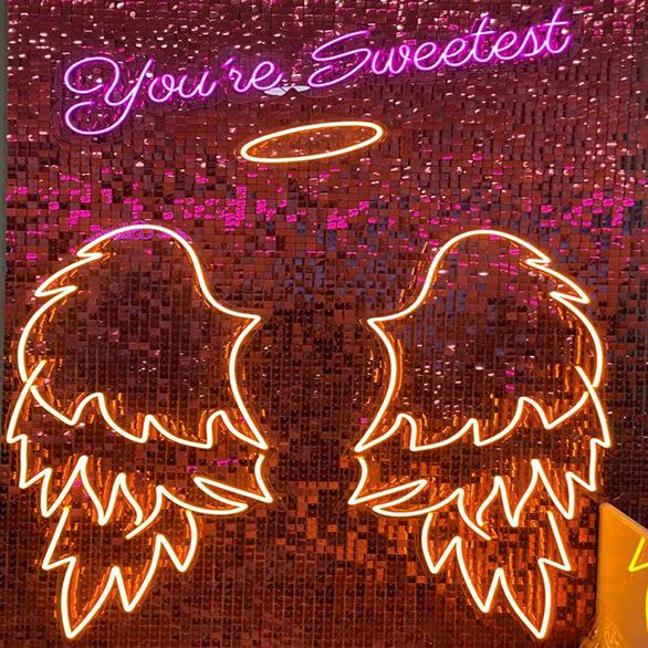 Pink You're Sweetest lettering above illuminated neon angel wings